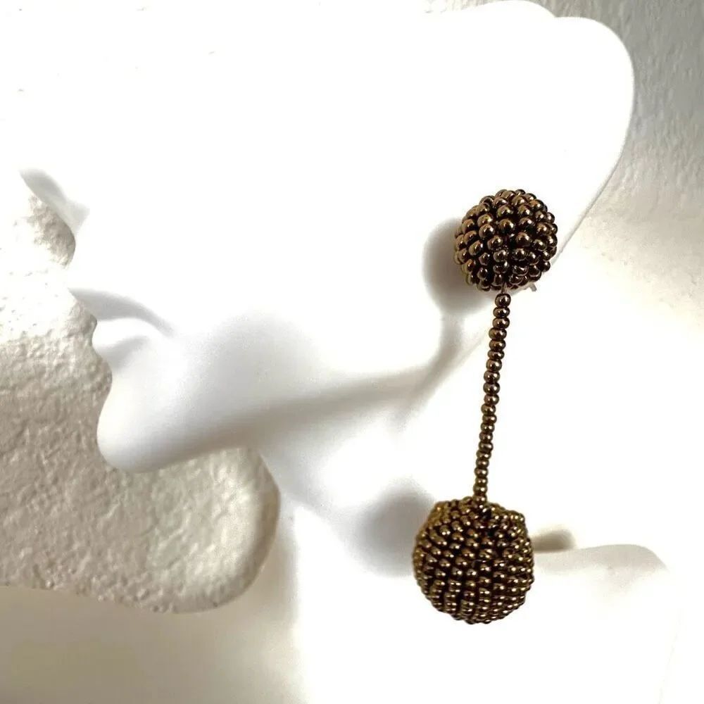 Gold tone beaded doubleโball drop post earrings